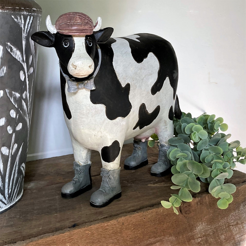 black and white cow in boots figurine 